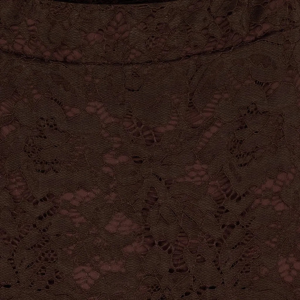 Nærbilde av brunt skjørt med blondermønster, viser detaljert tekstur og design.