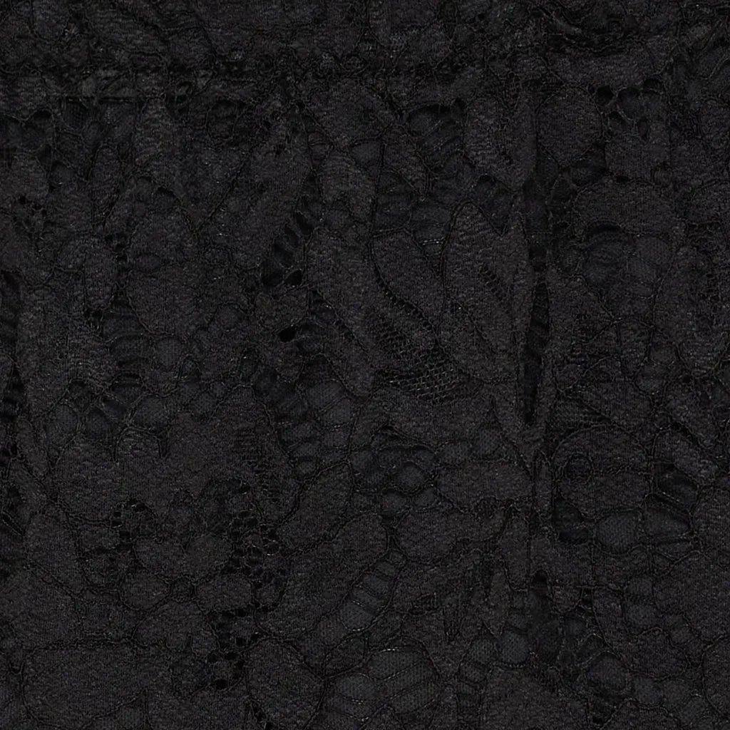 Nærbilde av svart skjørt med komplekst blondemønster og elastisk liv.