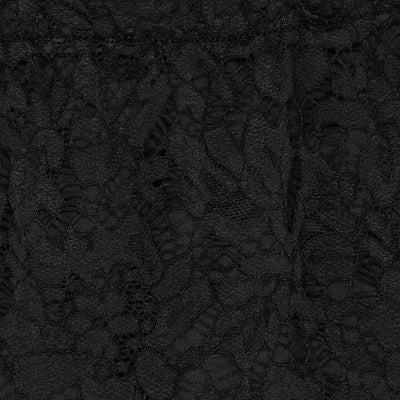 Nærbilde av svart skjørt med komplekst blondemønster og elastisk liv.