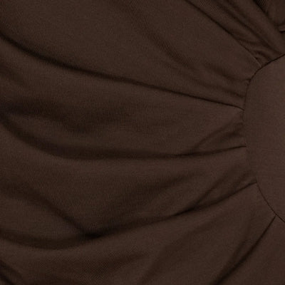 Nærbilde av brun, drapert stoff med tekstur, del av MdcPrimrose bluse.