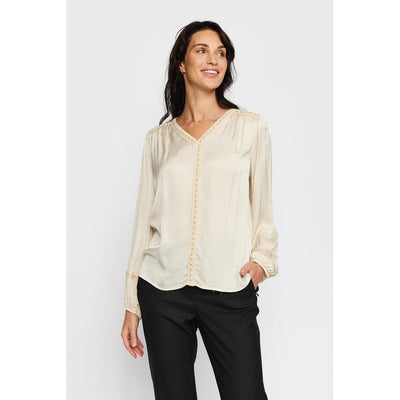 Lys bluse med V-hals og blondedetaljer, plisserte skuldre og elastiske mansjetter.