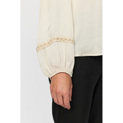 Lys bluseerm med elastisk mansjett og blondedetaljer.