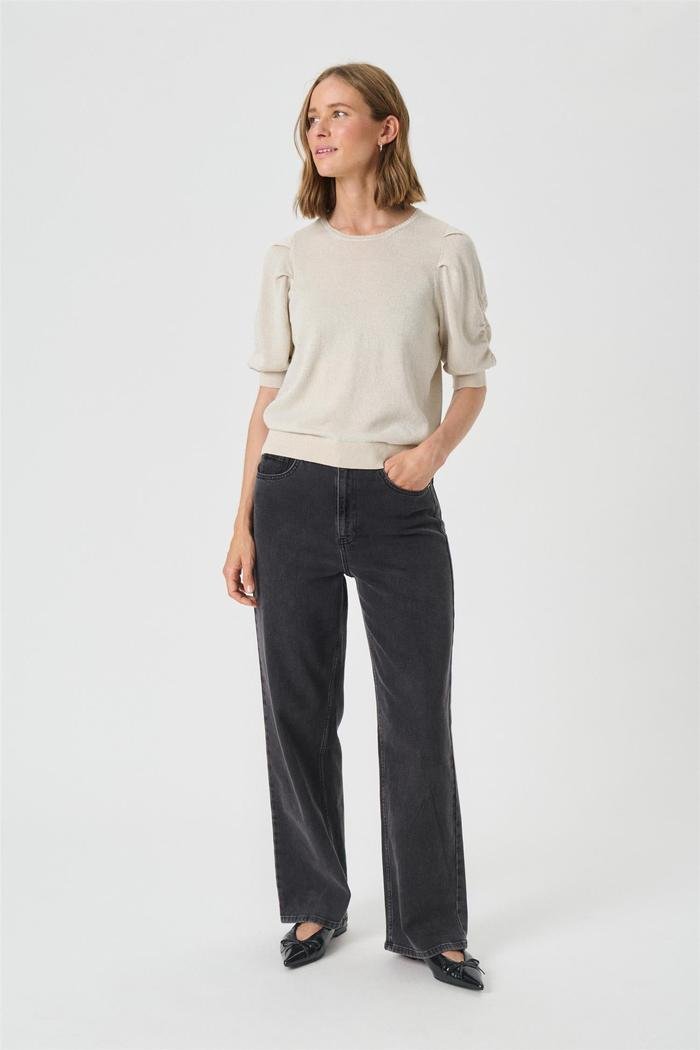Lys genser med rund hals, korte posete ermer, ribbekant. Kombinert med mørke, vide jeans.