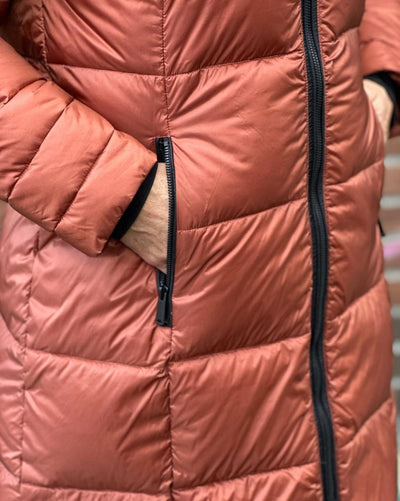 Quilted dunjakke i rustfarge med synlig glidelås og hånd i lomme.