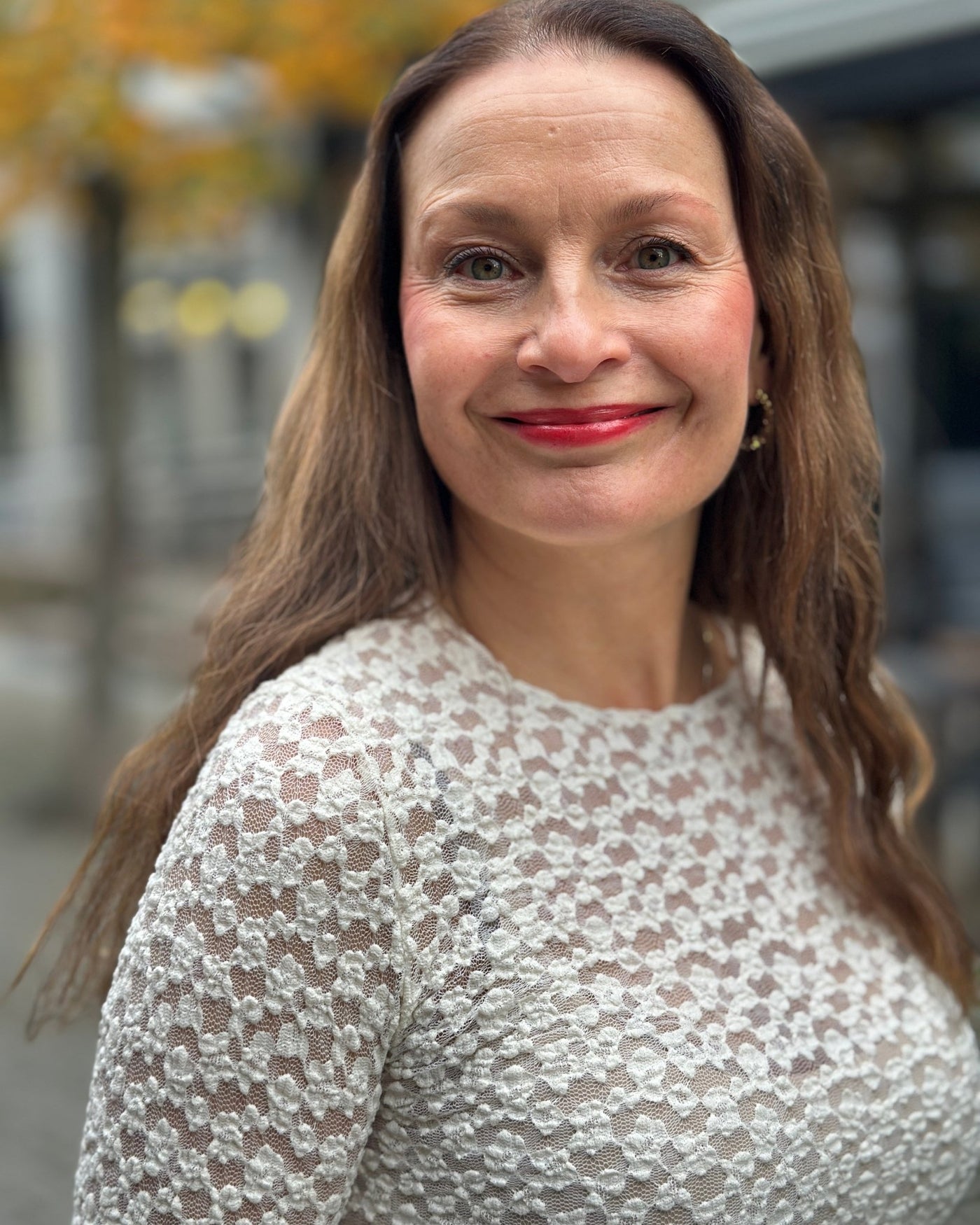 Person i tettsittende, langermet topp med blondeaktig mønster.
