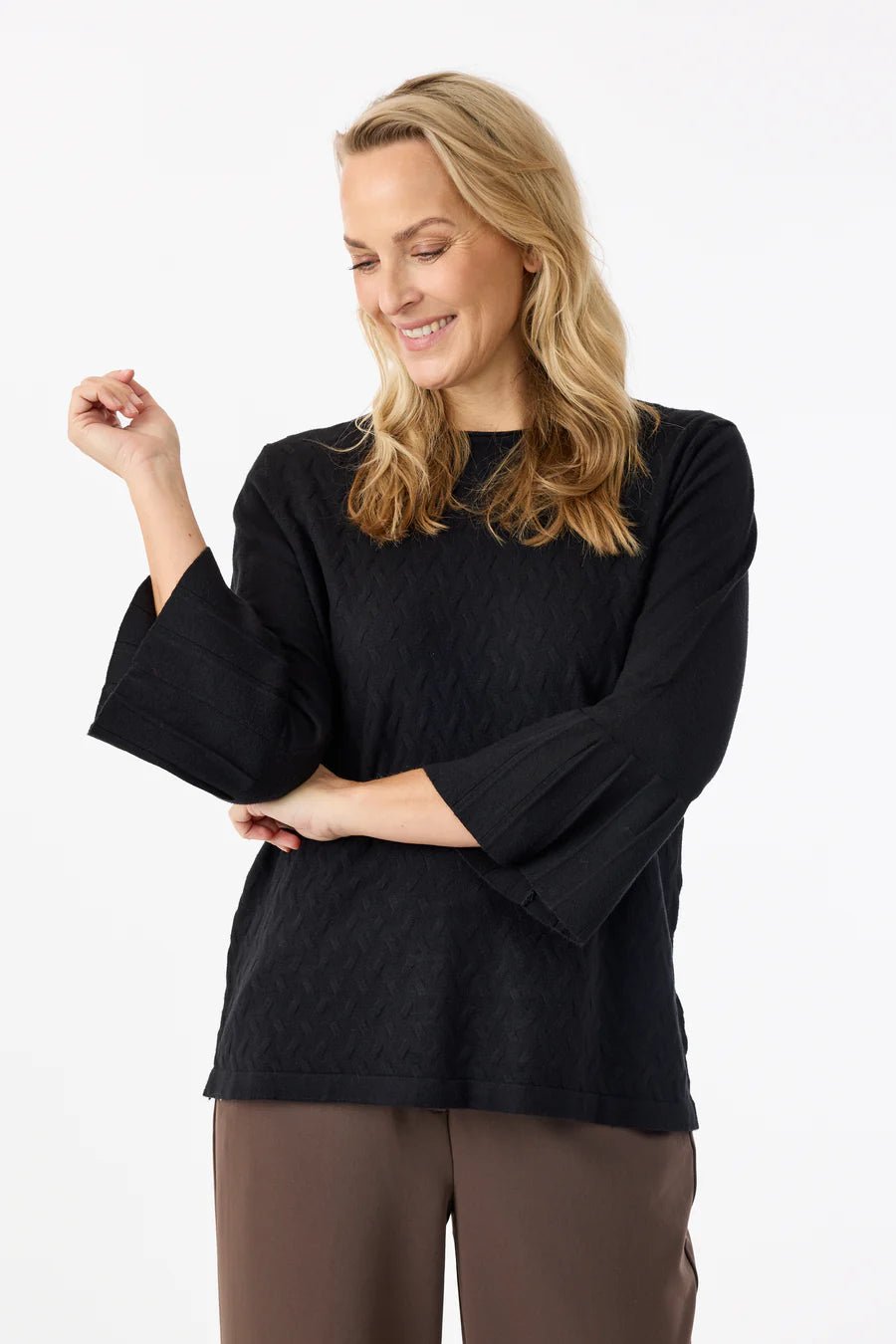 Svart genser med 3/4 ermer, subtile mønstre og dekorative detaljer på ermene.