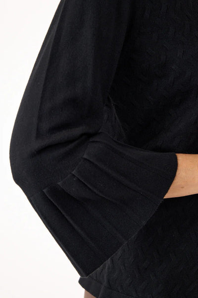 Svart genser med 3/4 ermer, subtilt mønster og dekorative detaljer på ermene.