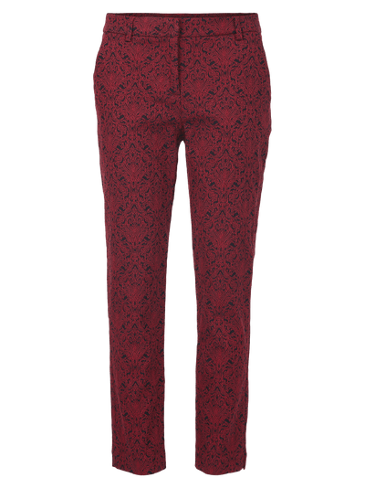 Bukser med mørkt detaljert mønster på lysere bakgrunn, beltehemper synlige.