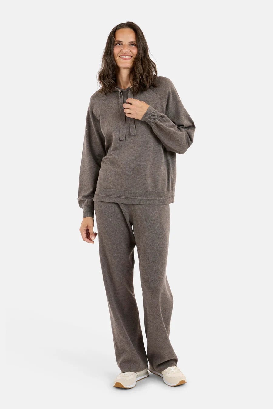 Kvinne i grå 78 Kosebukse m/strikk, løs passform, brede ben, matchende genser, og joggesko.