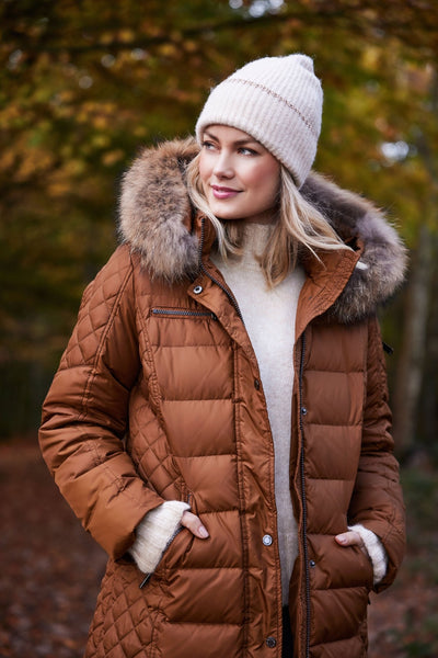 Lang brun dunkåpe med pelskantet hette, horisontale og diagonale sømmer, høstlandskap.