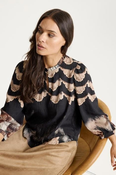 Kvinne med Simone Blouse med bølgete mønster i flere farger, lange ermer og løs passform.