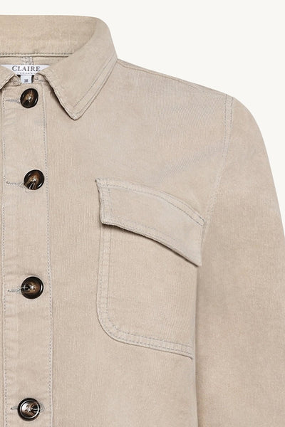 Beige cordskjorte med knappelukking, klassisk krage og brystlomme med klaff.