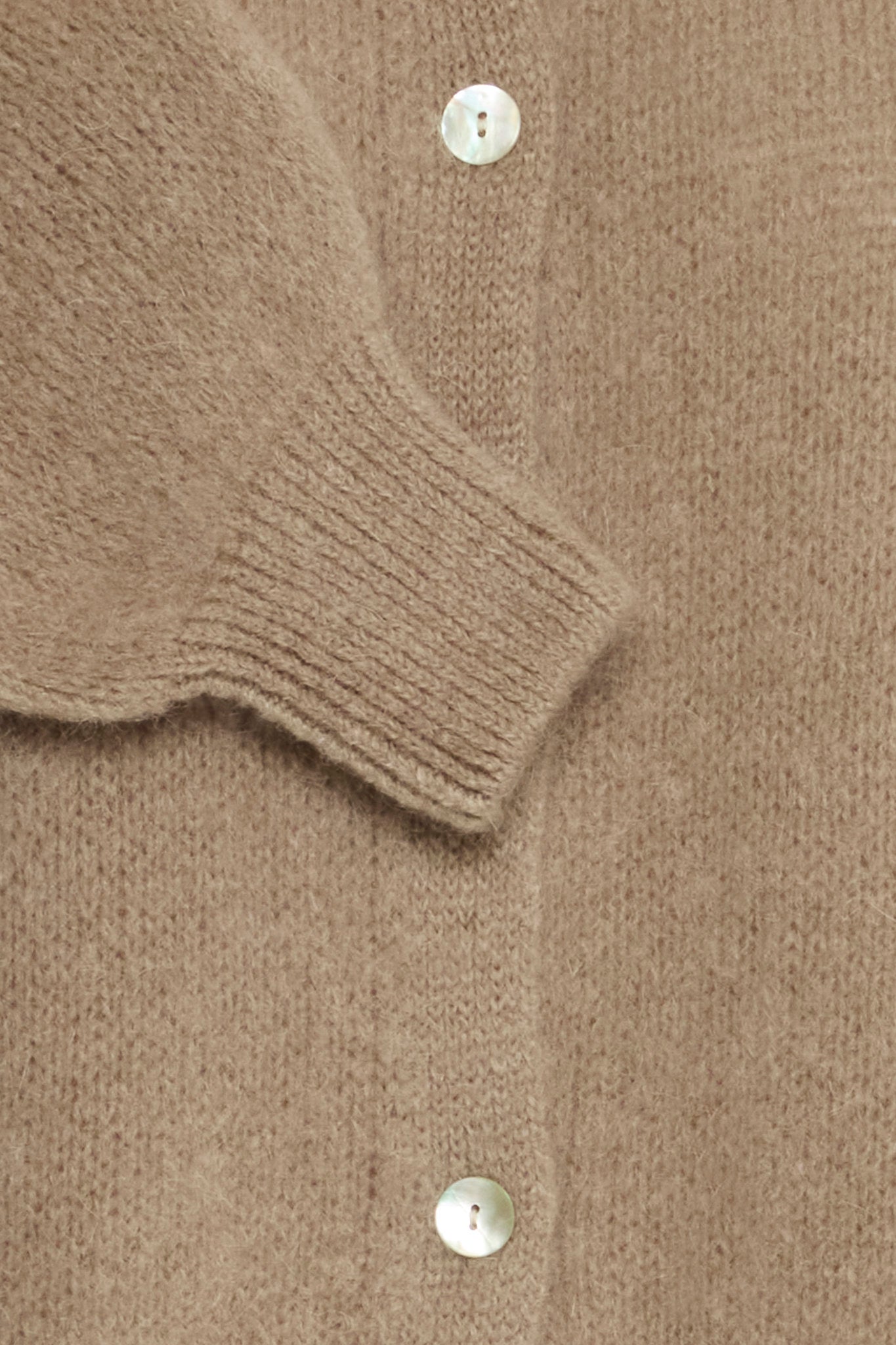 Beige strikket cardigan med ribbestrikkede mansjetter og synlige knapper.