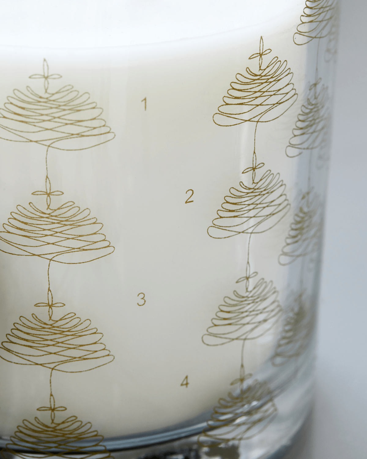 Lys i glass med gullmønstre og tallene 1 til 4. Flere veker i lyset.