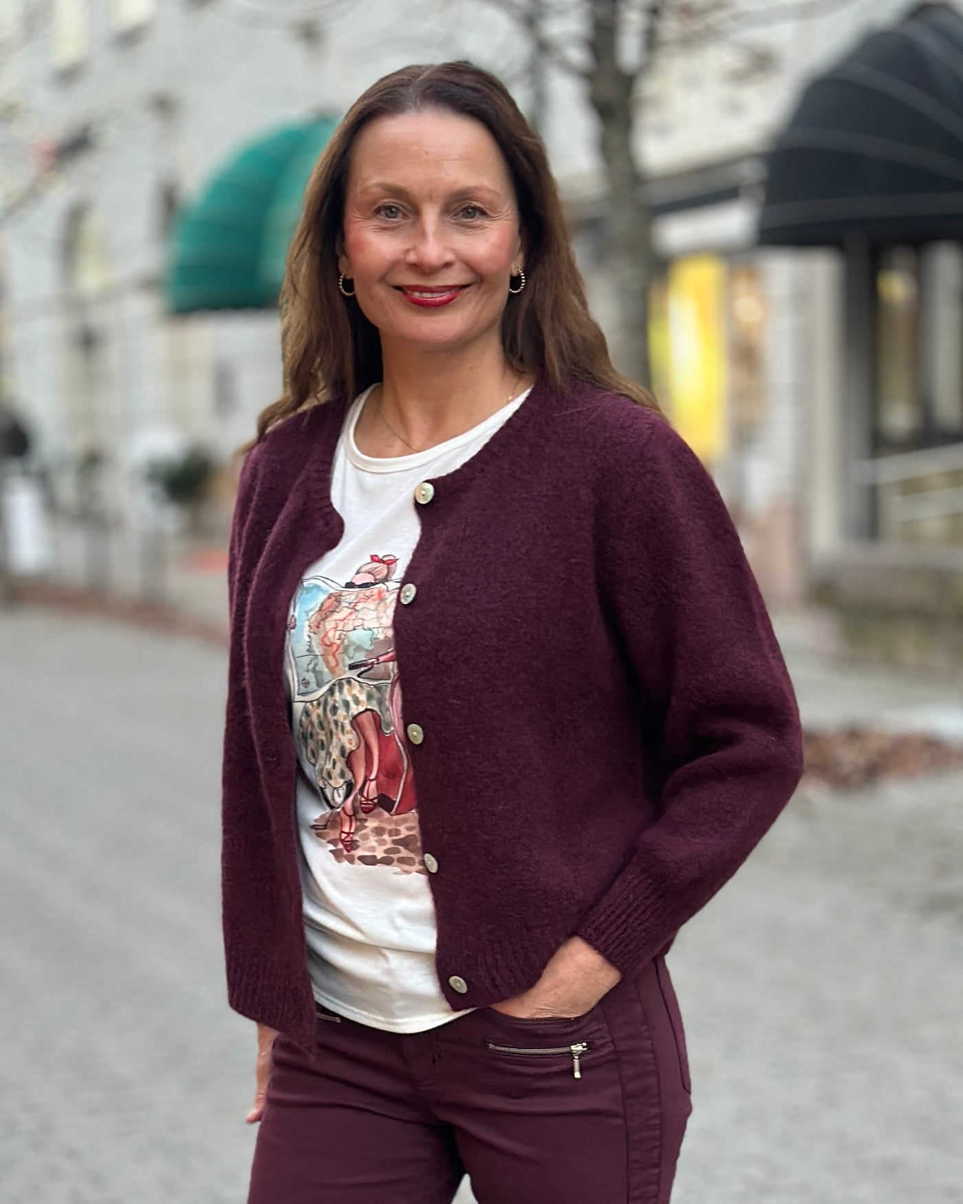 T-skjorte med trykk av en person på en rød scooter som leser et kart, "Vespa" synlig.