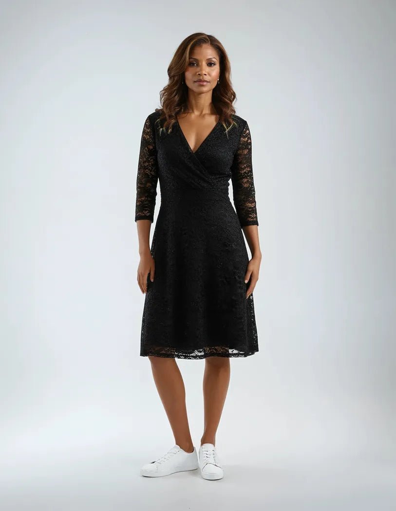 Kjole med trekvart blondeermer, V-utringning, omslagsstil og lett glitter.