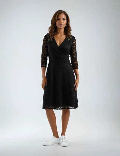 Kjole med trekvart blondeermer, V-utringning, omslagsstil og lett glitter.