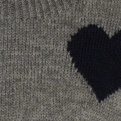 Grå genser med mørkt hjerte-mønster, nærbilde av strikketeksturen.
