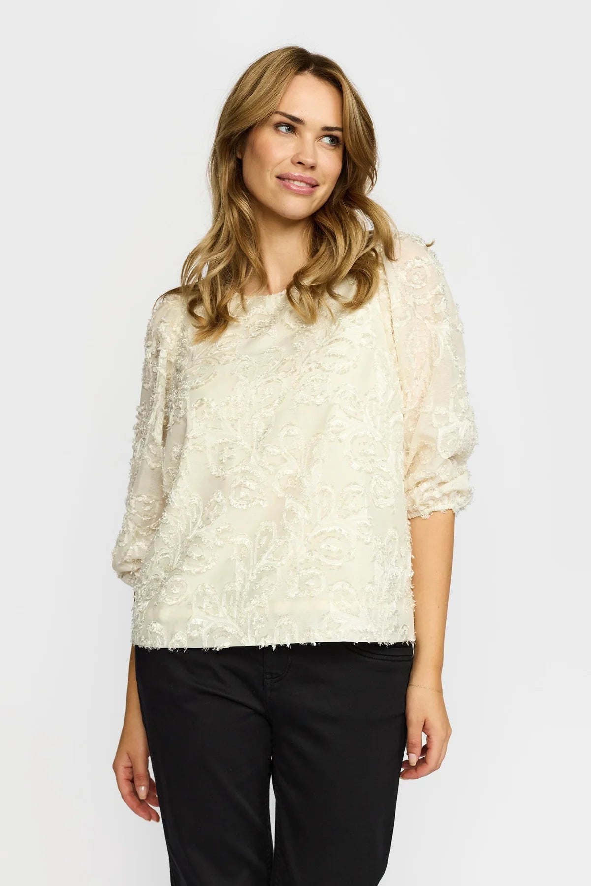 Kvinne iført Mira Bluse med teksturert mønster, trekvartermer og rund hals.