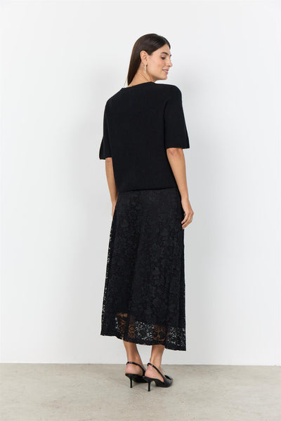 Sort plagg med korte ermer, strikket tekstur og runde blomsterknapper.