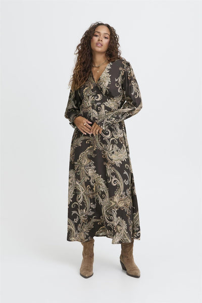 Modell i Sbolivia Paisley-kjole med lange ermer, V-hals og brune støvler.